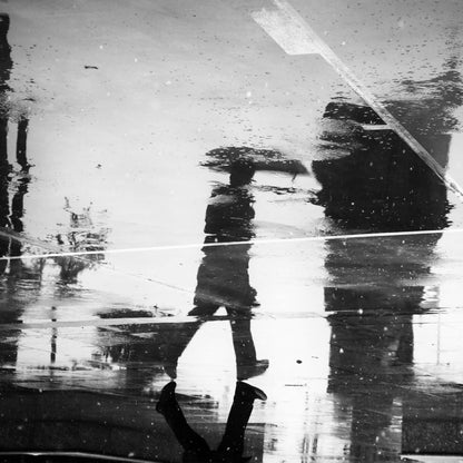 Man's reflection on a wet street